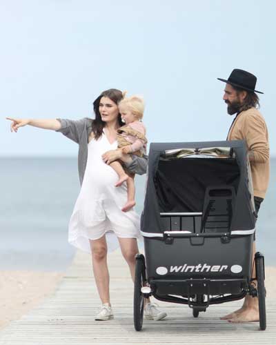 Familie mit Kind und Dreirad Lastenrad am Strand