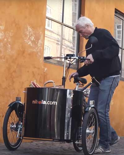 Älterer Herr steigt auf kompaktes Dreirad Lastenrad